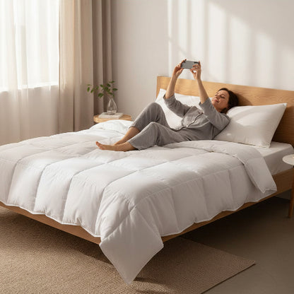 Couette 220x240 blanche femme allongée avec portable