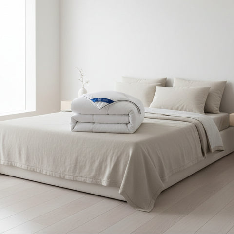 Couette 220 x 240 pliée déposée sur lit