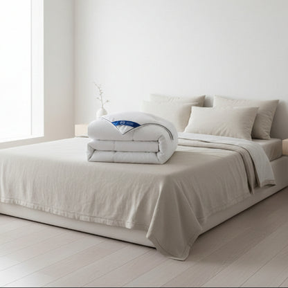 Couette 220 x 240 pliée déposée sur lit