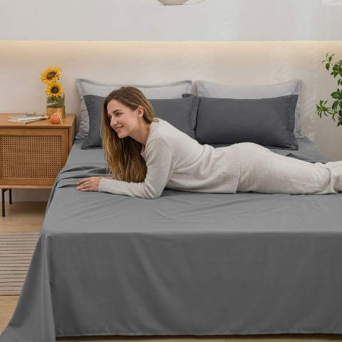 Drap plat gris chambre femme souriante allongée