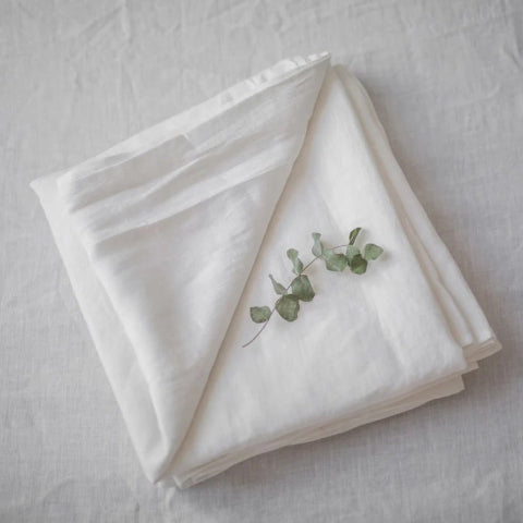 Draps lin pur blanc semi-blanchi plié sur lit