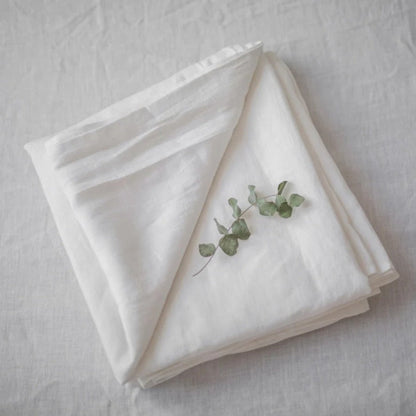 Draps lin pur blanc semi-blanchi plié sur lit
