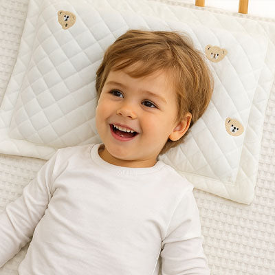 Oreiller pour bébé couché sur le dos souriant