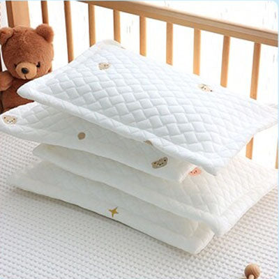 Oreiller pour bébé empilé sur le lit