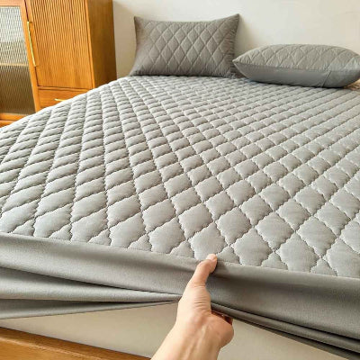 Protège matelas imperméale main tenant bordure devant  lit