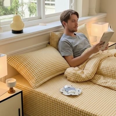 Taie d'oreiller jaune homme adossé avec livre mains