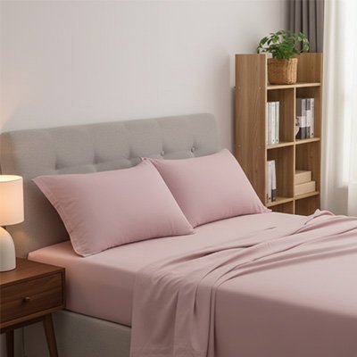 Taie d'oreiller rose déposée sur tête de lit